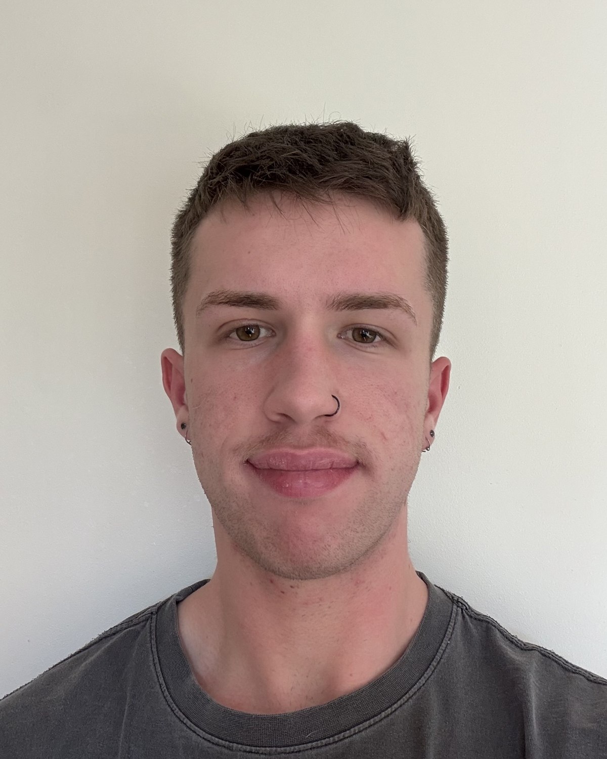 Portrait photo of Nick, smiling, against a plain light background